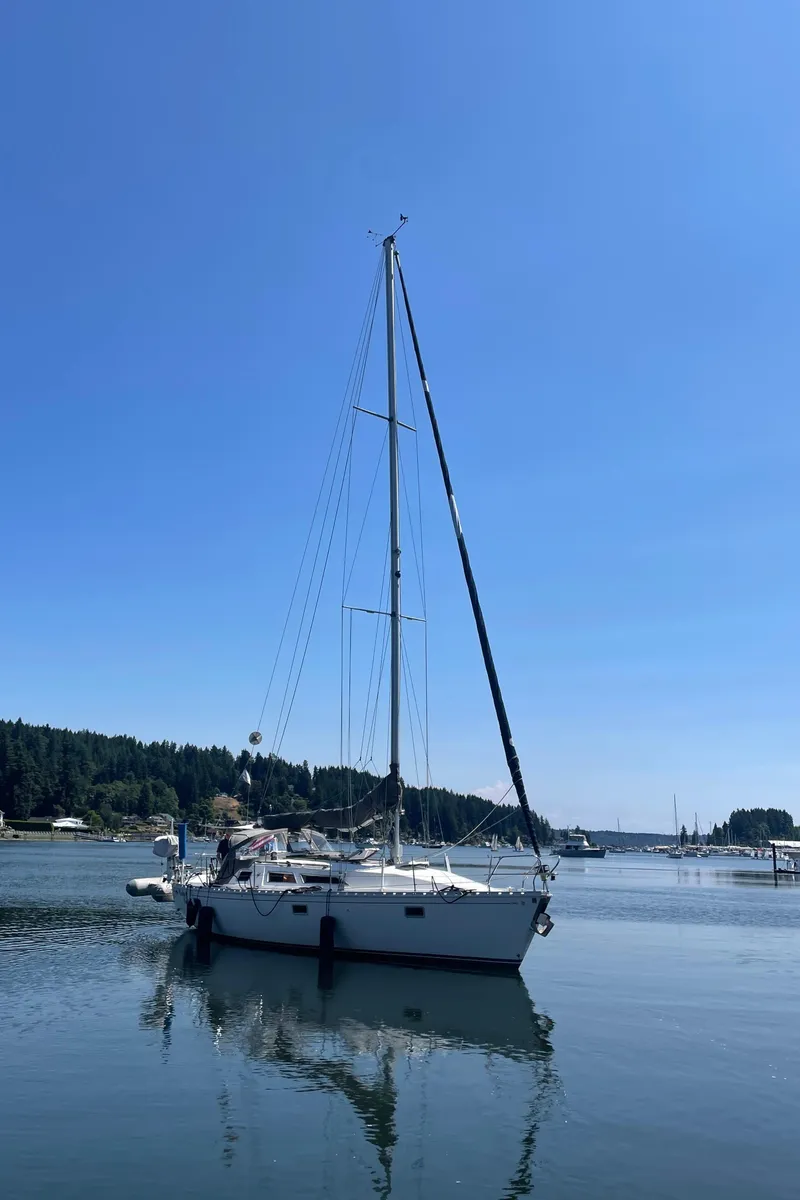 Slide: The Image of Jeanneau Sun Odyssey 36 sailboat from 1990 on calm water under clear blue sky. - 7