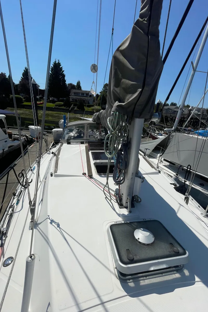 Slide: The Image of Jeanneau Sun Odyssey 36 sailboat deck, 1990 model, docked in a marina under clear skies. - 8