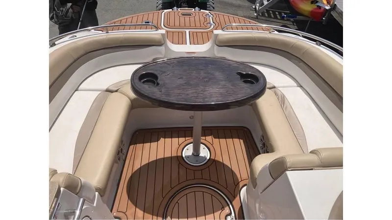 Slide: The Image of 2019 Starcraft MDX 191 O/B boat interior with cushioned seating and wooden table. - 7