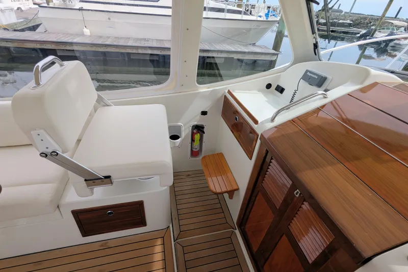 Slide: The Image of 2005 MJM 34z Downeast boat interior with white seating and wooden accents. - 14
