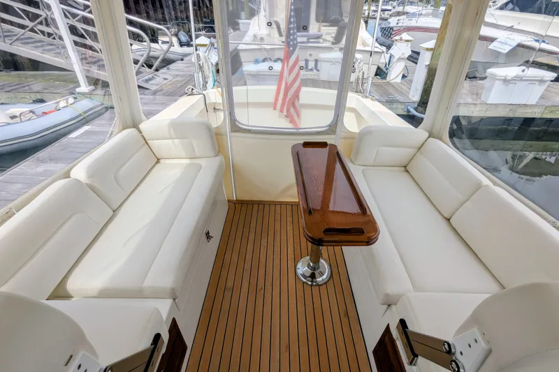 Slide: The Image of 2005 MJM 34z Downeast boat interior with white seating and wooden table. - 15