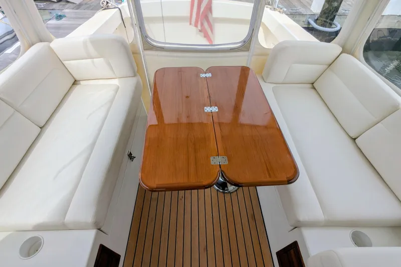 Slide: The Image of 2005 MJM 34z Downeast boat interior with wooden table and white seating. - 17