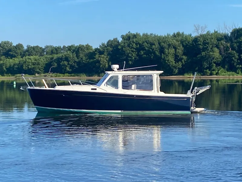 Slide: The Image of 2005 MJM 34z Downeast boat cruising on a calm lake with forested shoreline. - 2