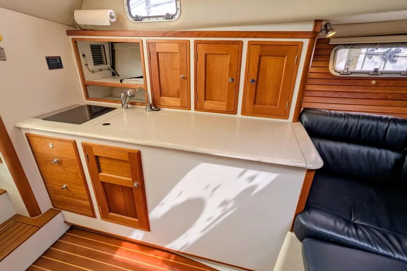 Slide: The Image of 2005 MJM 34z Downeast yacht interior with wooden cabinetry and compact kitchen area. - 25