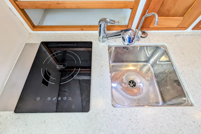 Slide: The Image of Modern kitchen area in 2005 MJM 34z Downeast boat with induction cooktop and stainless steel sink. - 26