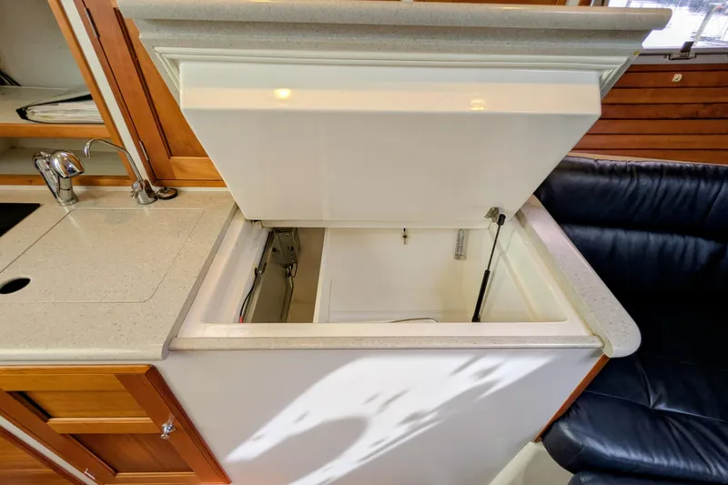 Slide: The Image of Open storage compartment in 2005 MJM 34z Downeast boat interior, featuring countertop and sink. - 27