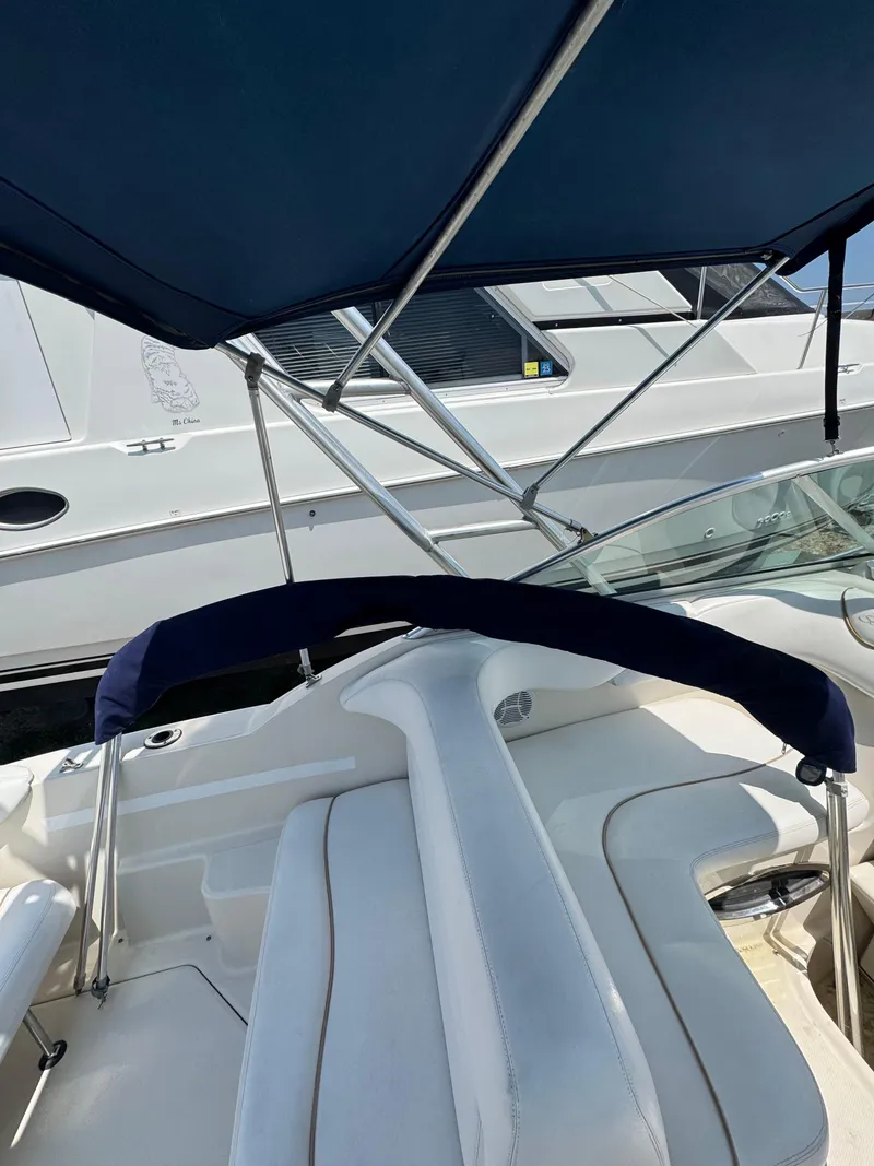 Slide: The Image of 2003 Sea Ray 240 Sundancer boat interior with blue canopy and white seating. - 13