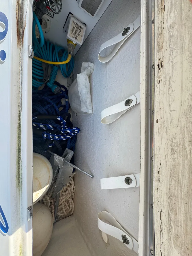 Slide: The Image of Storage compartment of a 2003 Sea Ray 240 Sundancer with ropes and equipment. - 3