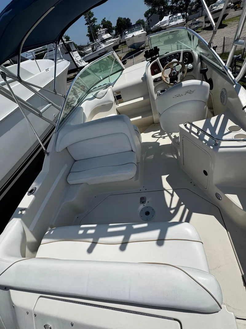 Slide: The Image of 2003 Sea Ray 240 Sundancer boat interior with white seating and steering wheel. - 4