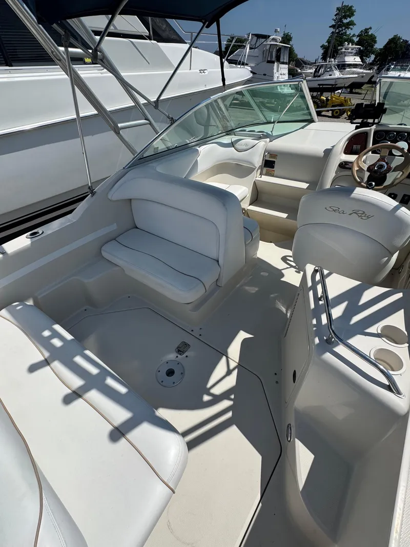 Slide: The Image of 2003 Sea Ray 240 Sundancer boat interior with white seating and steering wheel. - 5