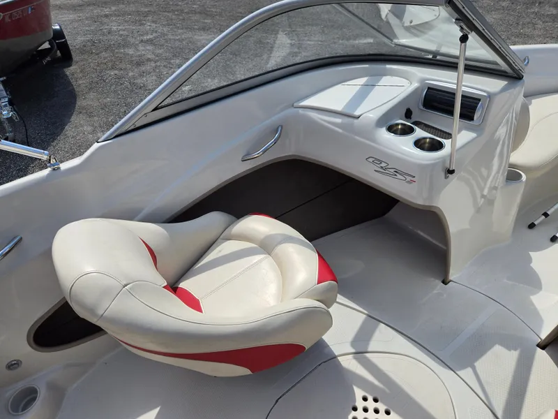 Slide: The Image of 2014 Tahoe Q5i boat interior with white and red seating, dashboard, and cup holders. - 11