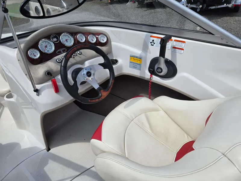 Slide: The Image of Interior of a 2014 Tahoe Q5i boat with steering wheel and dashboard controls. - 12