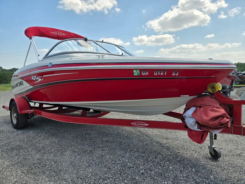 Slide: The Image of 2014 Tahoe Q5i red boat on trailer under blue sky. - 2