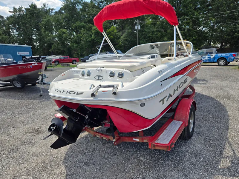 Slide: The Image of 2014 Tahoe Q5i boat on trailer, red and white, parked outdoors. - 4
