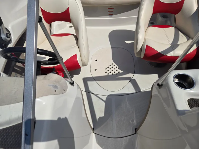 Slide: The Image of 2014 Tahoe Q5i boat interior with red and white seating and steering wheel. - 9