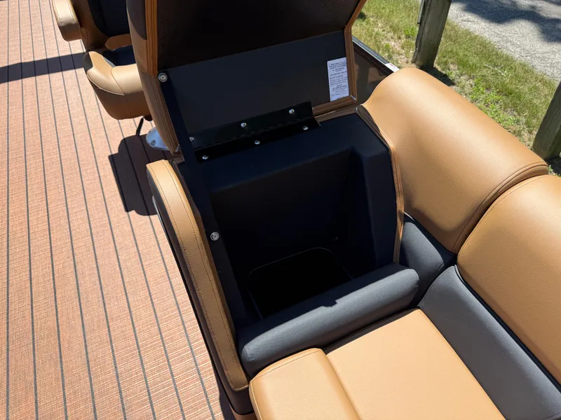 Slide: The Image of 2026 Bentley Pontoons Elite 253 Admiral interior storage compartment with tan and black seating. - 15