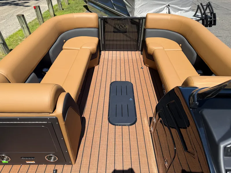 Slide: The Image of 2026 Bentley Pontoons Elite 253 Admiral interior with tan seating and wood-style flooring. - 28