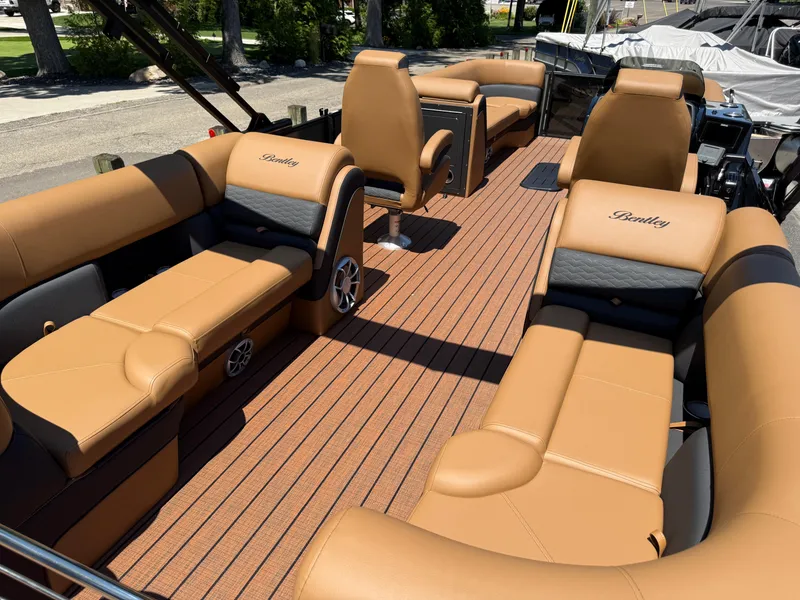 Slide: The Image of 2026 Bentley Pontoons Elite 253 Admiral interior with luxurious tan seating and wood-style flooring. - 36