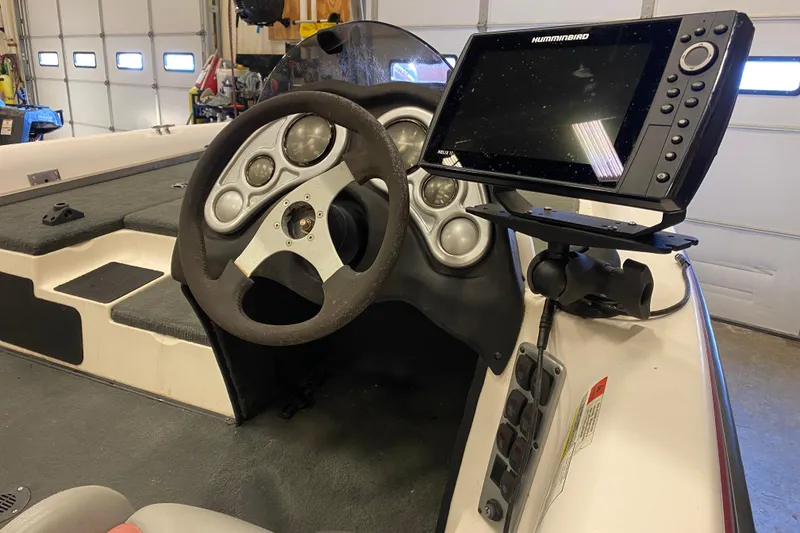 Slide: The Image of 2005 Stratos 275 Pro XL boat dashboard with steering wheel and Humminbird fish finder. - 11