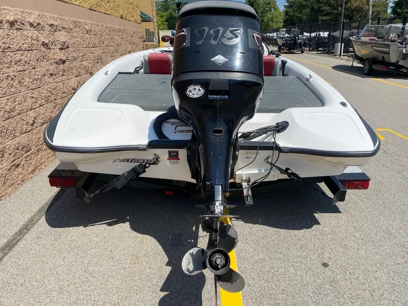 Slide: The Image of 2005 Stratos 275 Pro XL boat with outboard motor, parked on pavement. - 4