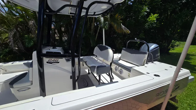 Slide: The Image of 2021 Robalo 246 Cayman boat with seating, console, and Yamaha engine in a lush setting. - 3