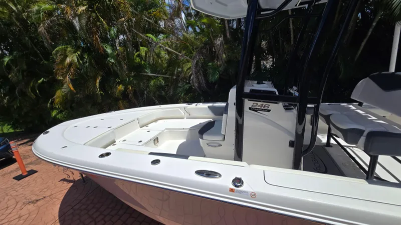 Slide: The Image of 2021 Robalo 246 Cayman boat with sleek design, parked on a brick driveway. - 4