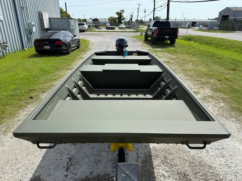 Slide: The Image of 2025 Alweld 1442 Marsh Jon boat on trailer, parked near vehicles. - 7