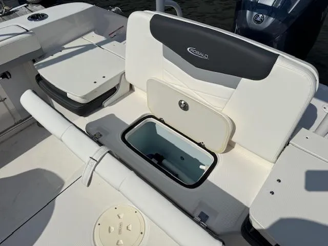 Slide: The Image of 2024 Robalo R207 Dual Console boat interior with storage compartment open. - 11