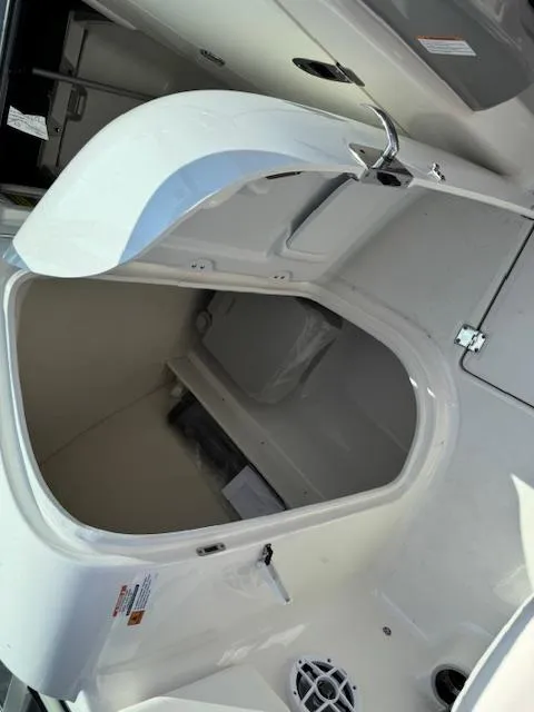 Slide: The Image of 2024 Robalo R207 Dual Console boat storage compartment with open hatch, showcasing interior space. - 12