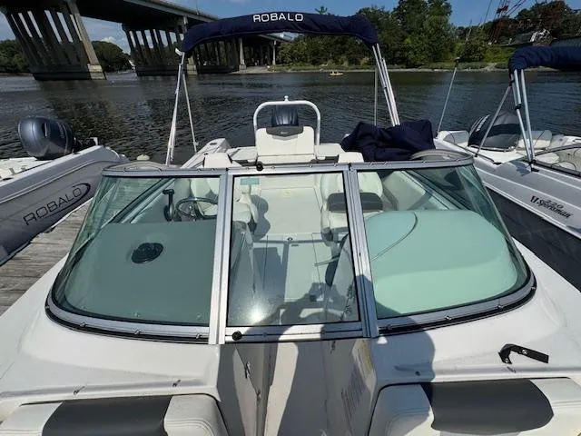 Slide: The Image of 2024 Robalo R207 Dual Console boat docked by a river under a bridge. - 20