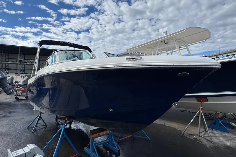 Slide: The Image of 2024 Robalo R207 Dual Console boat on stands under a cloudy sky. - 22