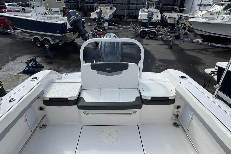 Slide: The Image of 2024 Robalo R207 Dual Console boat interior with seating and storage, docked among other boats. - 26
