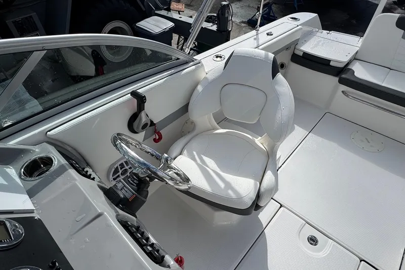 Slide: The Image of 2024 Robalo R207 Dual Console boat interior with steering wheel and seating. - 27