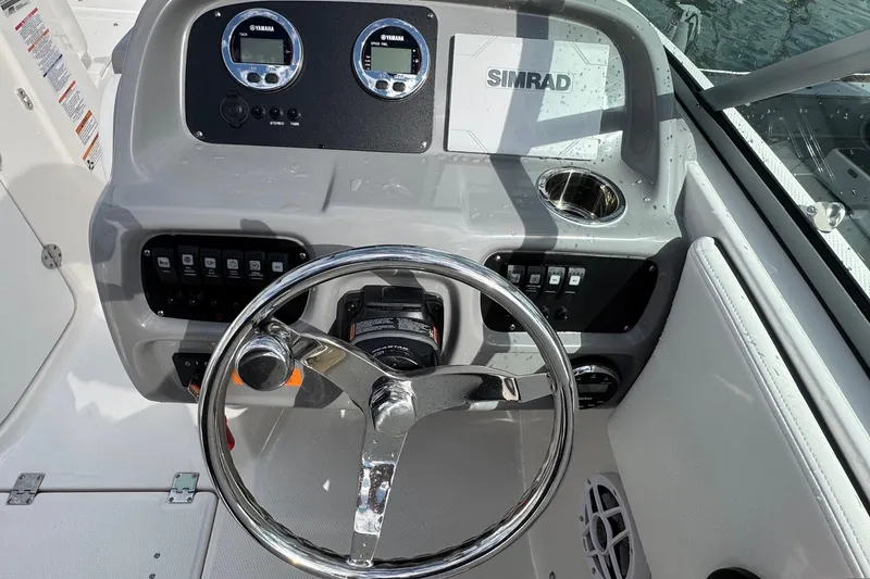 Slide: The Image of 2024 Robalo R207 Dual Console boat dashboard with steering wheel and controls. - 33