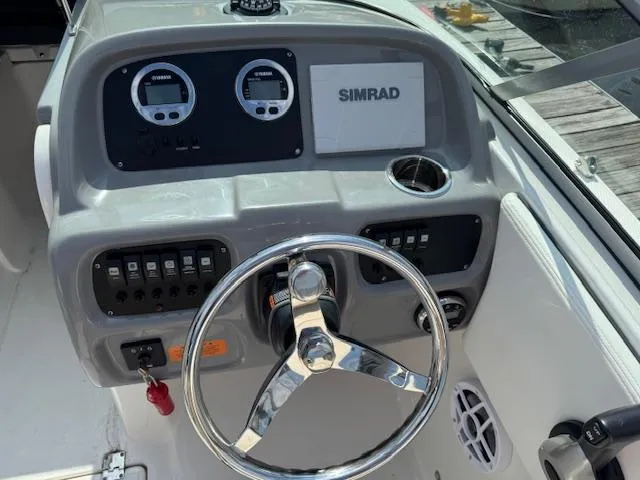 Slide: The Image of 2024 Robalo R207 Dual Console boat dashboard with steering wheel and Simrad display. - 4
