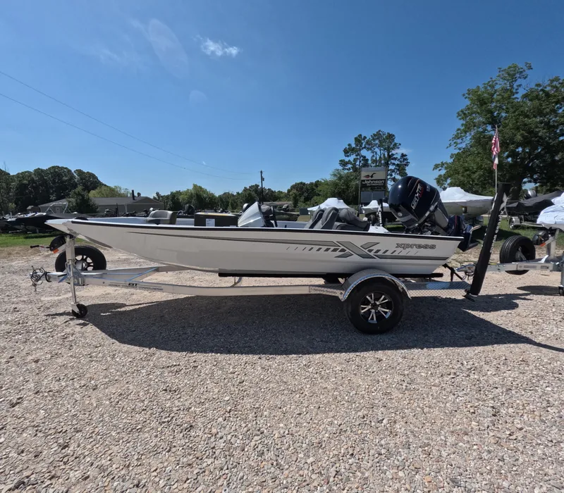 Slide: The Image of 2026 Xpress H 18 BASS boat on trailer, parked outdoors under clear blue sky. - 1