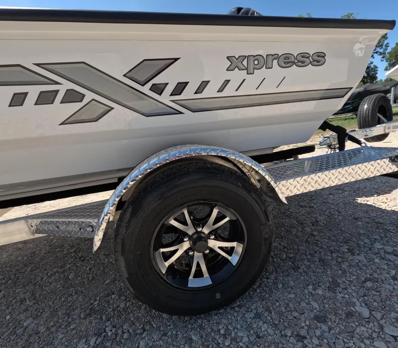 Slide: The Image of 2026 Xpress H 18 BASS boat on trailer, featuring sleek design and alloy wheels. - 8