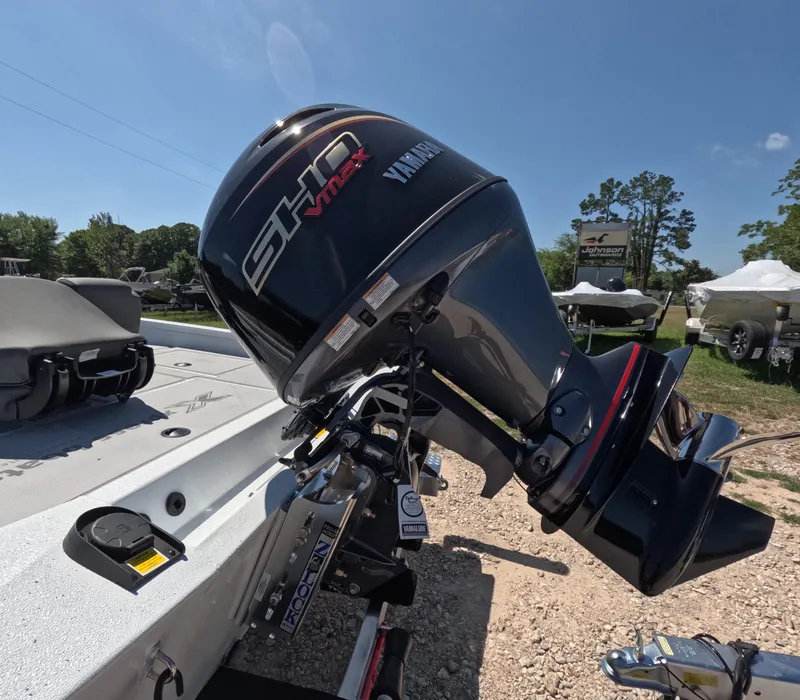 Slide: The Image of 2026 Xpress H 18 BASS boat with Yamaha VMAX engine, parked outdoors. - 9
