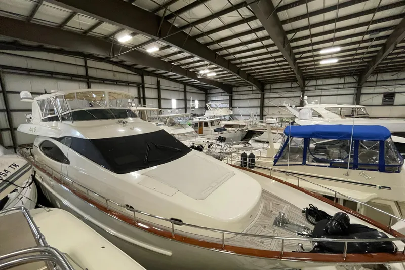 Slide: The Image of 2004 Azimut 74 yacht in indoor storage facility, surrounded by other boats. - 18