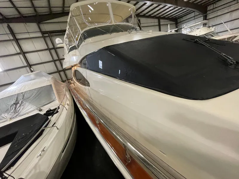 Slide: The Image of 2004 Azimut 74 yacht in storage, showcasing sleek design and covered deck. - 22