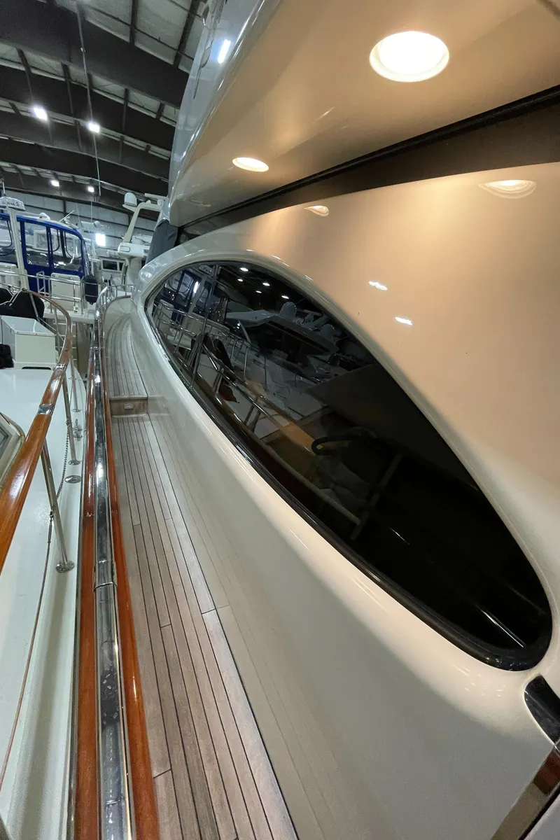 Slide: The Image of 2004 Azimut 74 yacht with sleek design and polished wood railing in a marina setting. - 28