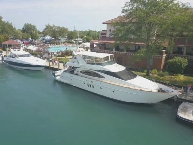 Slide: The Image of Luxury 2004 Azimut 74 yacht docked at marina, surrounded by lush greenery and waterfront buildings. - 6