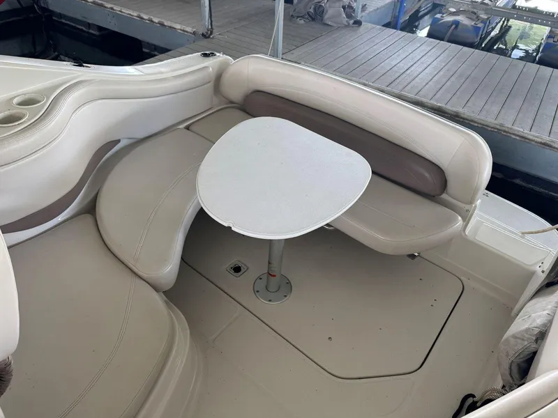Slide: The Image of 2000 Regal Commodore 2460 boat interior with seating and table, docked at marina. - 10