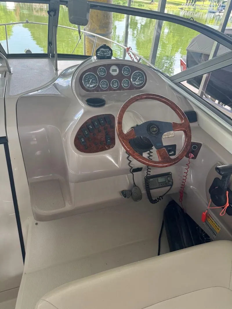 Slide: The Image of 2000 Regal Commodore 2460 boat dashboard with gauges and wooden steering wheel. - 12