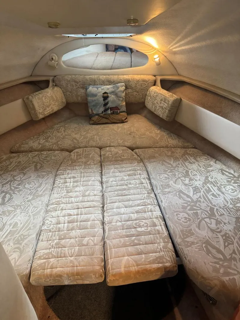 Slide: The Image of Cozy cabin interior of 2000 Regal Commodore 2460 with patterned cushions and lighthouse pillow. - 14