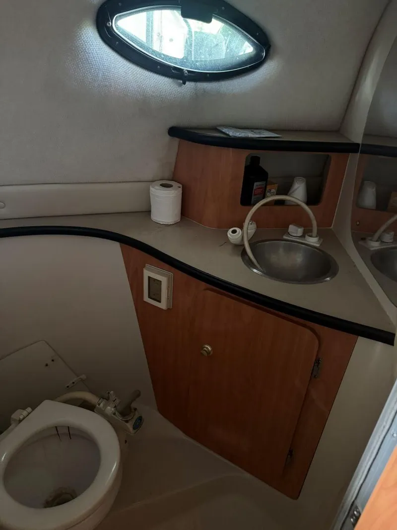Slide: The Image of Compact bathroom in a 2000 Regal Commodore 2460 boat with sink and toilet. - 21