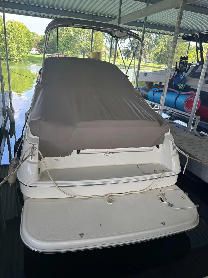 Slide: The Image of Covered 2000 Regal Commodore 2460 boat docked under a canopy. - 27