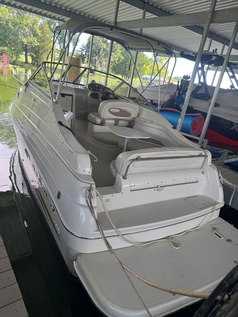 Slide: The Image of 2000 Regal Commodore 2460 boat docked under a covered marina, showcasing its spacious deck. - 4