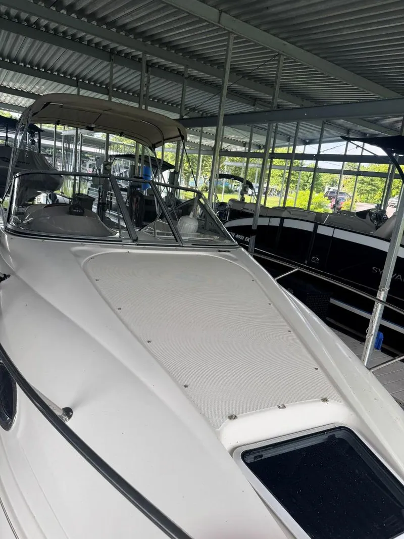 Slide: The Image of 2000 Regal Commodore 2460 boat docked under a metal canopy. - 6