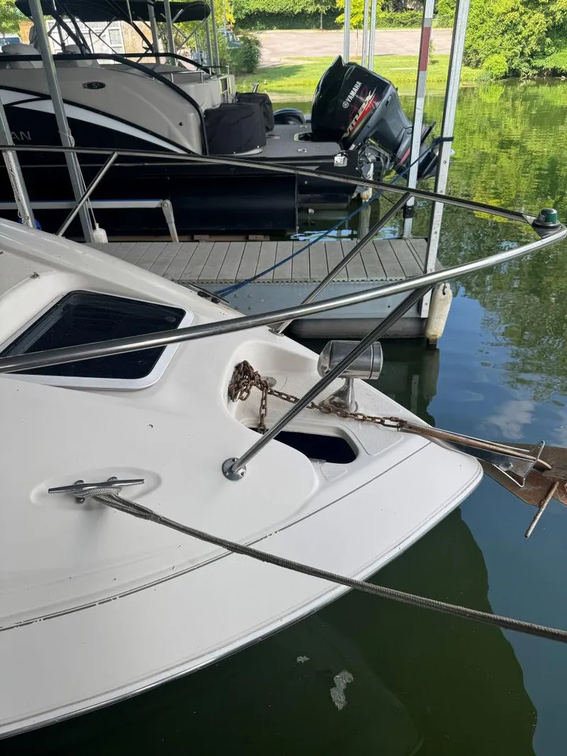 Slide: The Image of 2000 Regal Commodore 2460 boat docked, showing anchor and railing details. - 7